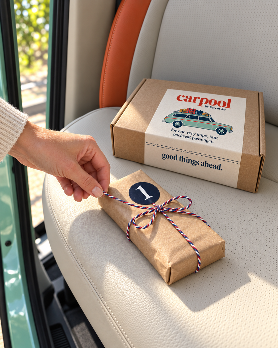 The moment: a hand reaching for Carpool parcel number one on the back seat, the Carpool box behind it