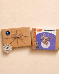 Kraft parcel number 1 beside the Kitsville fluttering butterfly build-it kit, the takeoff activity in The Navigator box for kids 6 to 8